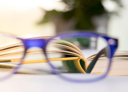 Glasses against blurred book in background